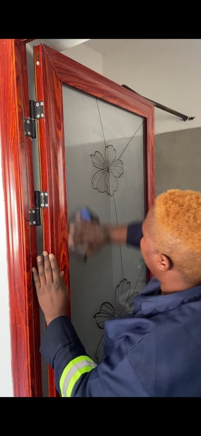 A Lavender cleaner wiping a glass-panelled door