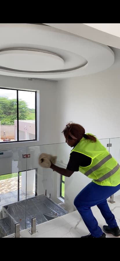 A Lavender cleaner wiping a glass balustrade
