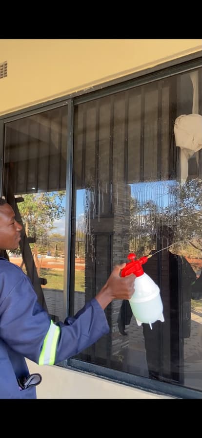 A Lavender cleaner washing a window